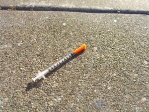 Used needle and syringe on sidewalk